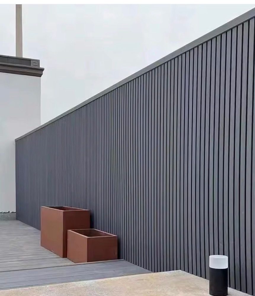 Fencly WPC Cladding: charcoal fluted composite boards used as an exterior feature wall on a rooftop terrace.