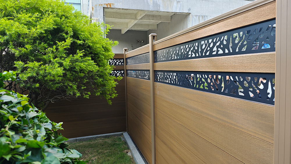 Fencly Carving Fence — laser-cut aluminium decorative inserts mounted in WPC composite panel with Leaf Vein pattern.